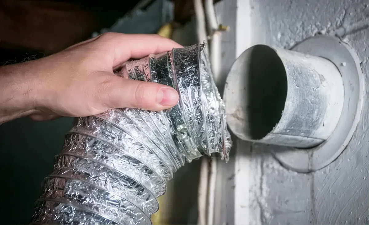 Technicien qui nettoie un conduit de sécheuse